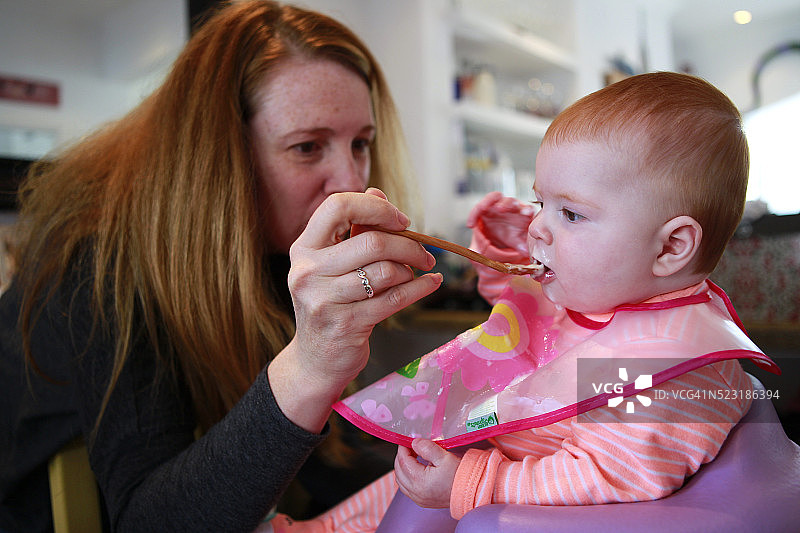六个月大的女孩第一次吃固体食物图片素材