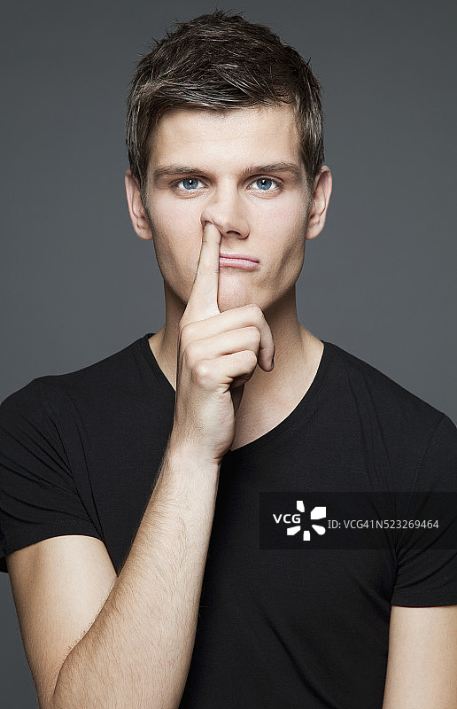 挖鼻孔的年轻男子图片素材