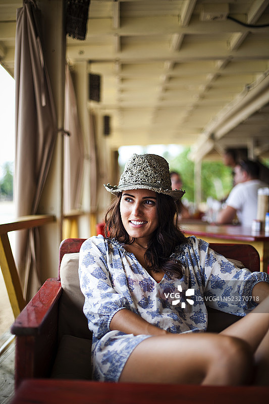 年轻女人从餐厅的露台上眺望大海，多米尼加共和国拉斯特伦纳斯图片素材
