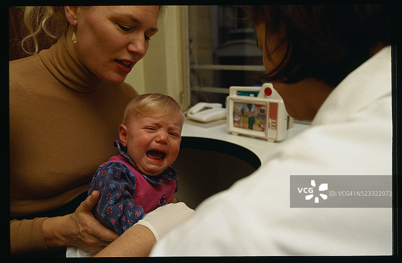 母亲在孩子免疫接种时抱着女儿图片素材