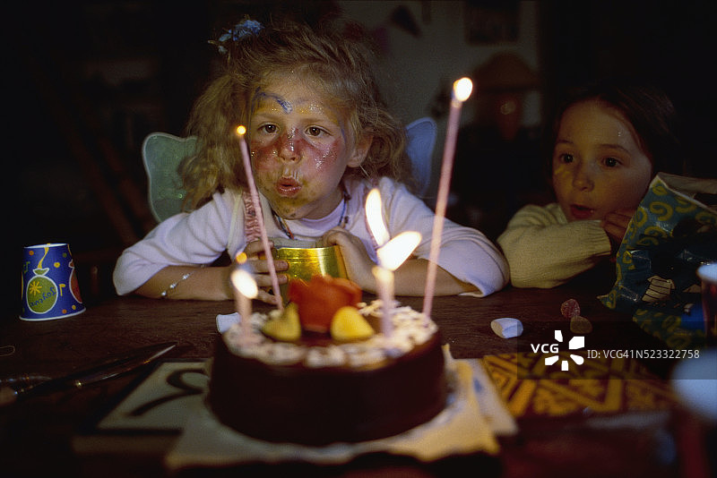 吹灭生日蛋糕蜡烛的女孩图片素材