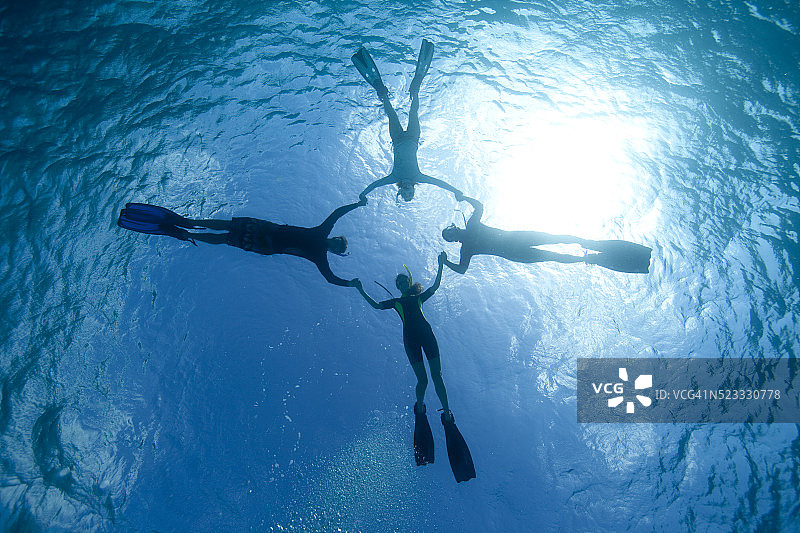 在开曼群岛大开曼岛，浮潜者嬉戏表演水上特技图片素材