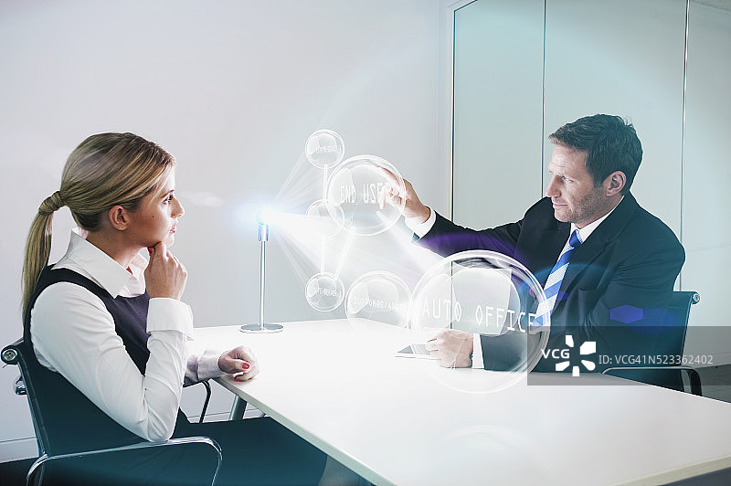 办公室同事观看未来设备投射的3D影像图片素材