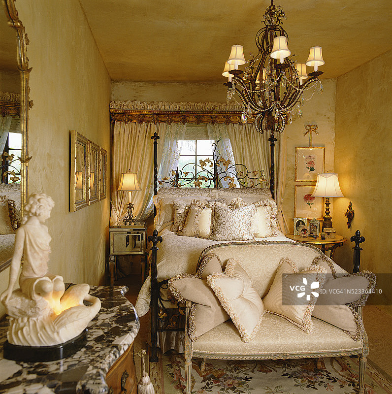 枝形吊灯下华丽床前的长椅图片素材