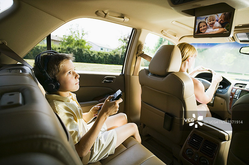 男孩在汽车后座看屏幕图片素材