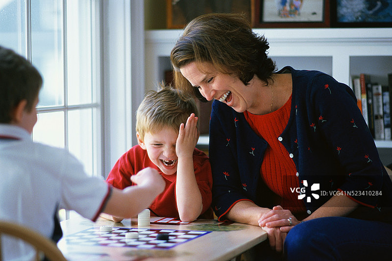 母亲看儿子们下跳棋图片素材