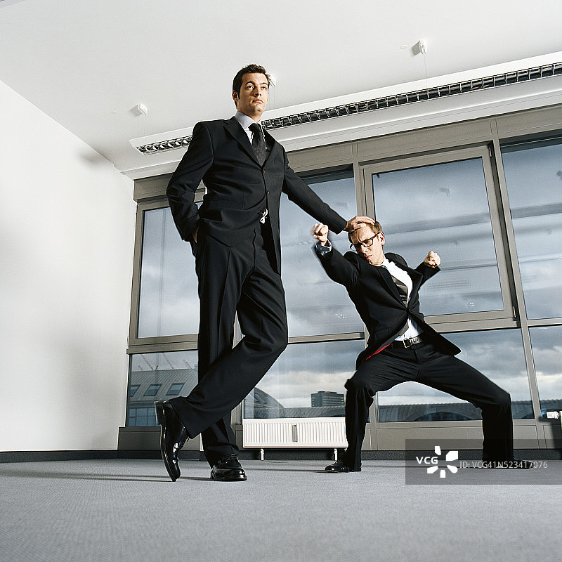 两位男商人在空旷的办公室里打架图片素材