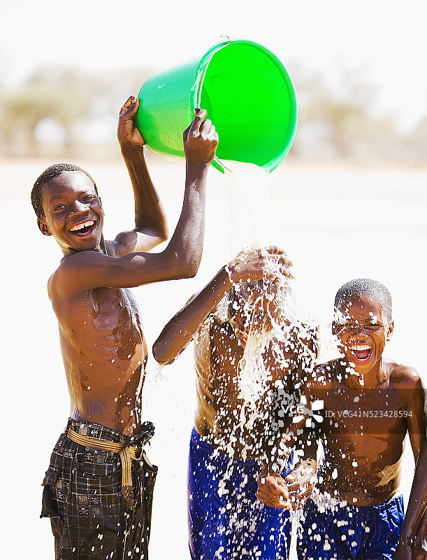 男孩向朋友们泼水图片素材