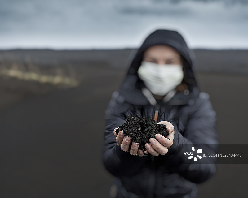女人拿着最近冰岛格里姆斯沃特火山爆发的新灰图片素材