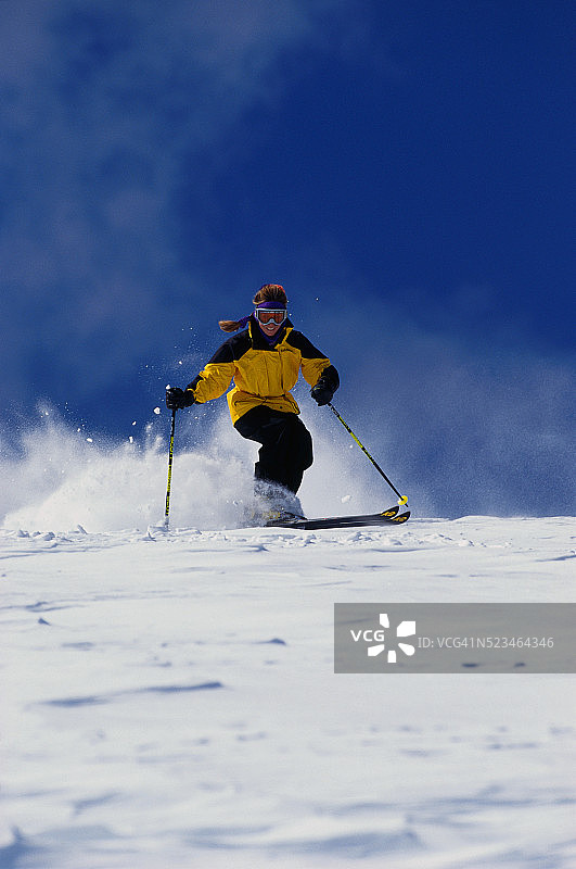 滑雪者在粉雪中滑雪下坡图片素材