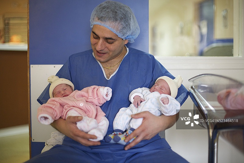 巴黎妇产医院：父亲与新生双胞胎图片素材
