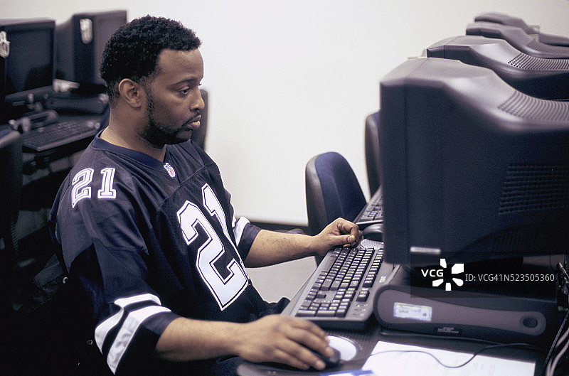 男子在社区中心用电脑工作图片素材