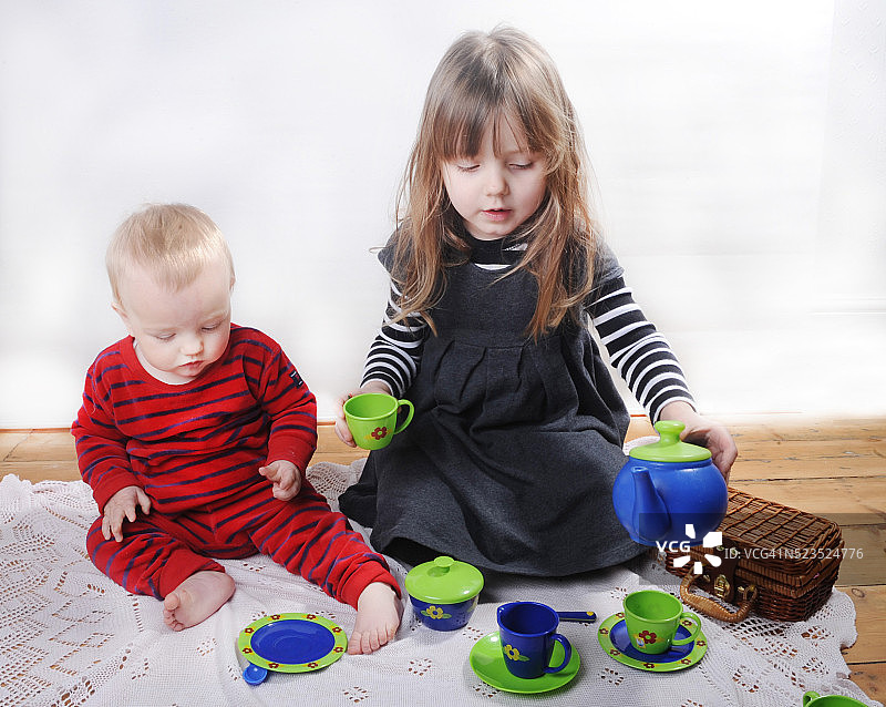 小女孩和妹妹一起玩茶话会图片素材