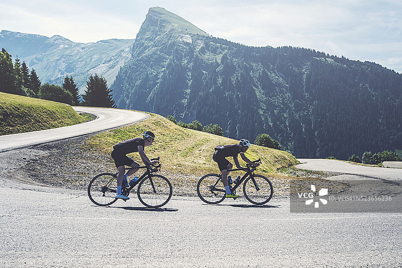 两名自行车手在法国阿尔卑斯山下坡骑行图片素材
