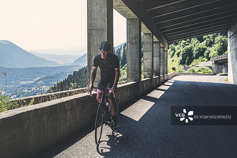 在阿尔卑斯山隧道中的老年男性自行车手图片素材
