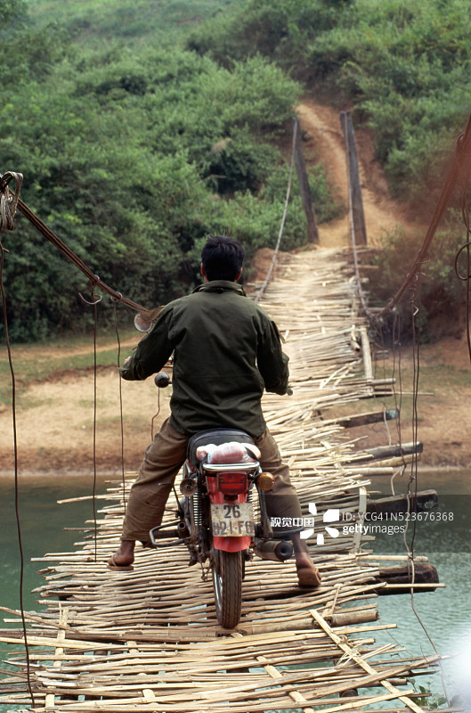 在摇摇晃晃的桥上的摩托车图片素材