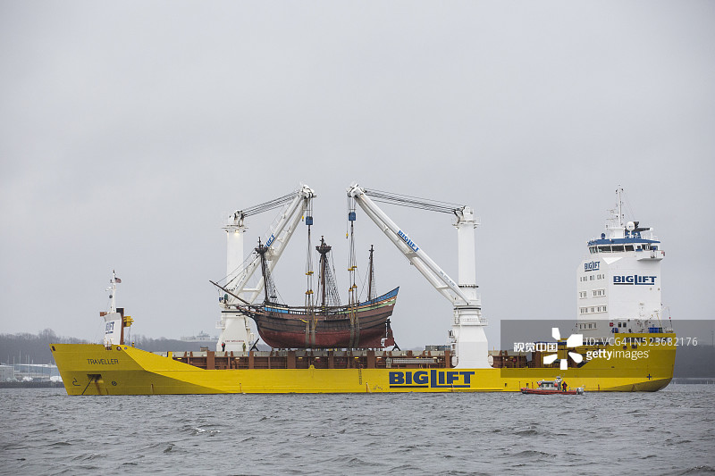 Biglift Traveller起重机吊起一艘大型木制帆船进行运输。图片素材
