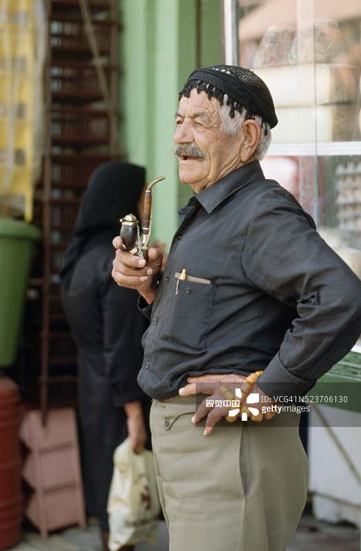 男人抽着烟斗并拿着琥珀手串图片素材