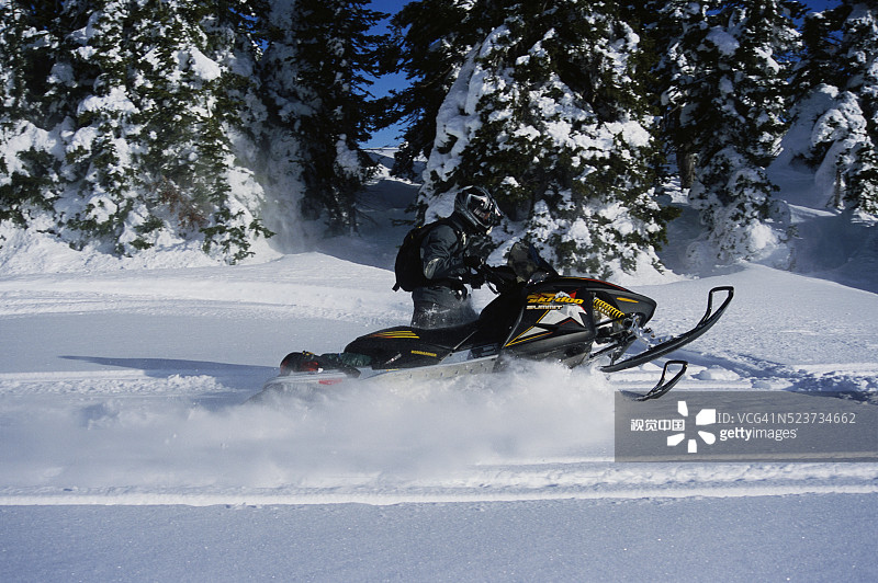 雪地摩托车手在厚厚的雪地上行驶图片素材