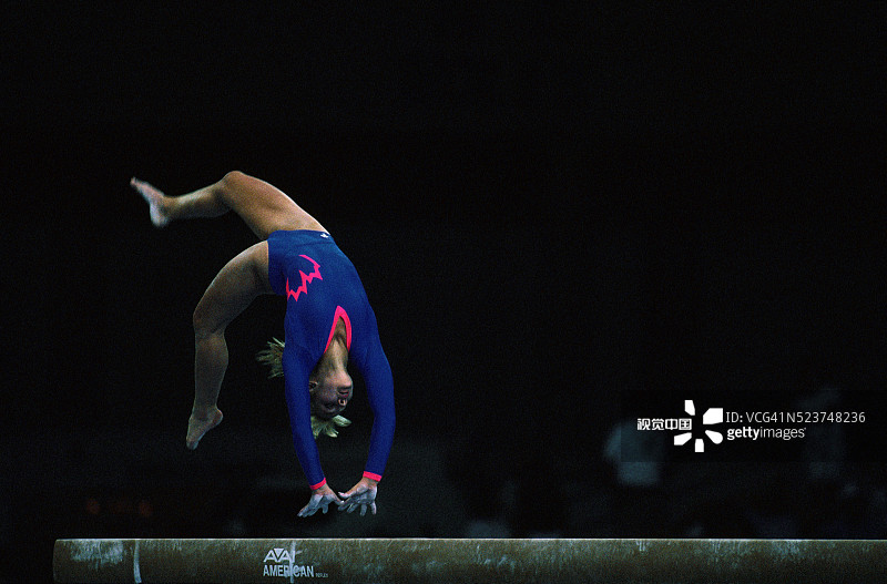 在平衡木上表演的体操运动员图片素材