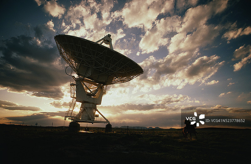 牧场主骑行经过射电望远镜图片素材