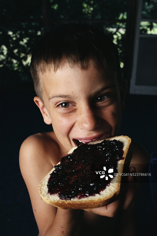 吃蓝莓酱吐司的男孩图片素材
