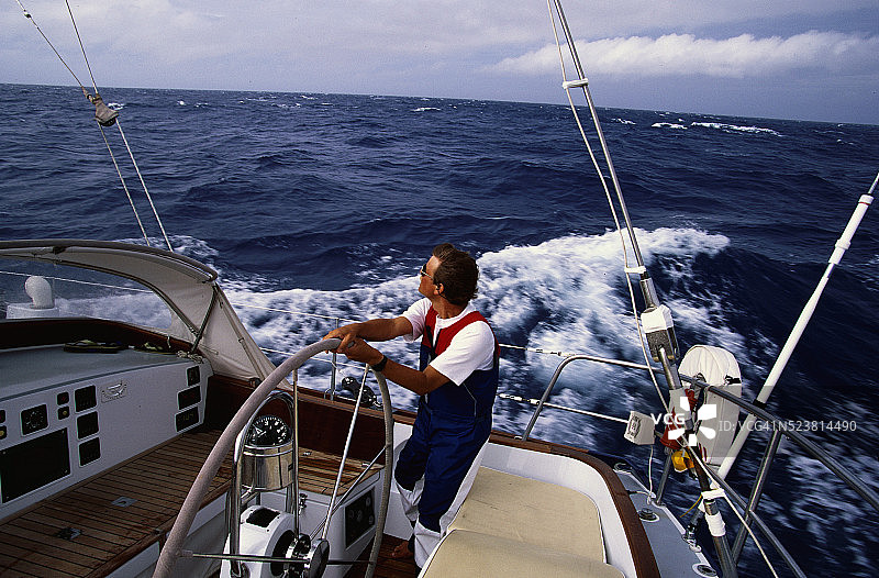 在波涛汹涌的水中驾驶游艇的船夫图片素材
