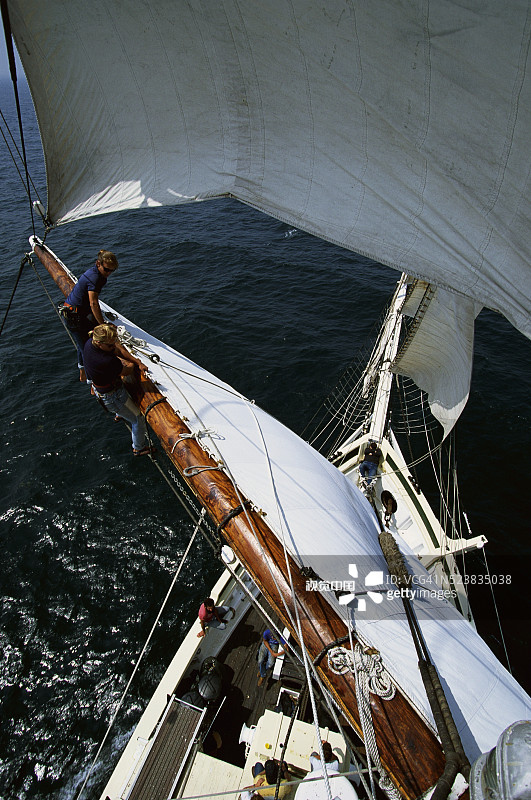 船员悬挂在船的桅桁上图片素材