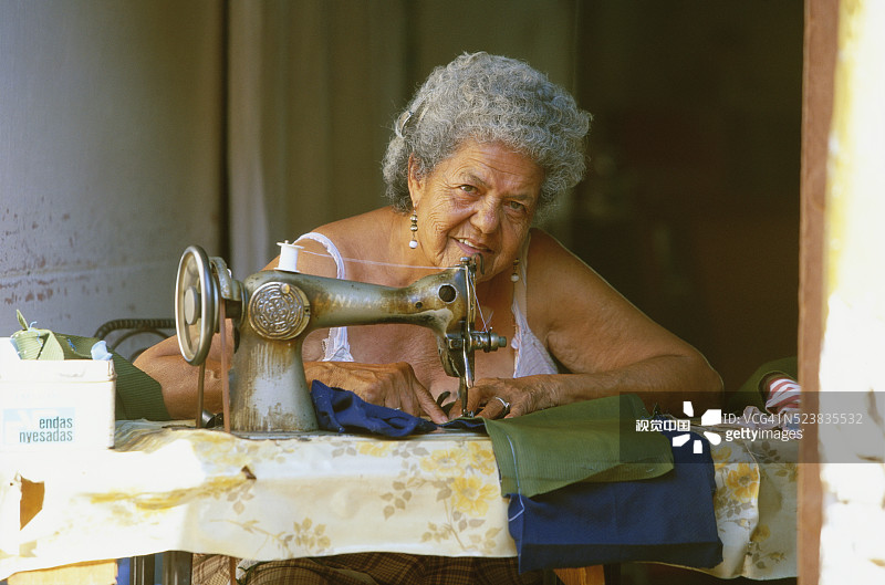 古巴妇女用旧缝纫机缝纫图片素材
