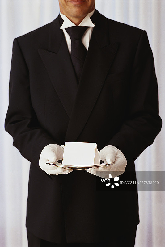 餐厅领班手持托盘上的邀请函图片素材