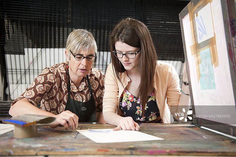 老师指导学生进行丝网印刷工艺图片素材