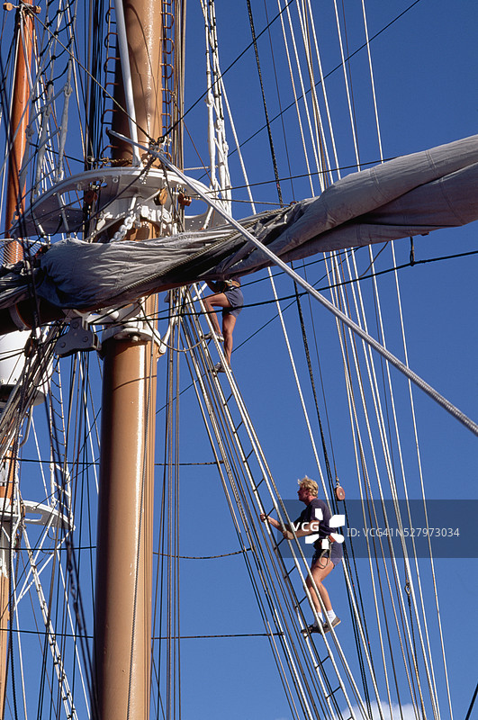 水手攀爬帆船的索具图片素材