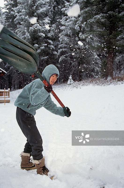 年轻女人铲雪图片素材