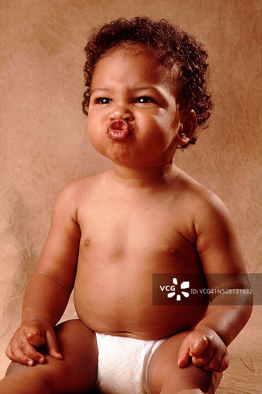 穿尿布的婴儿做鬼脸图片素材