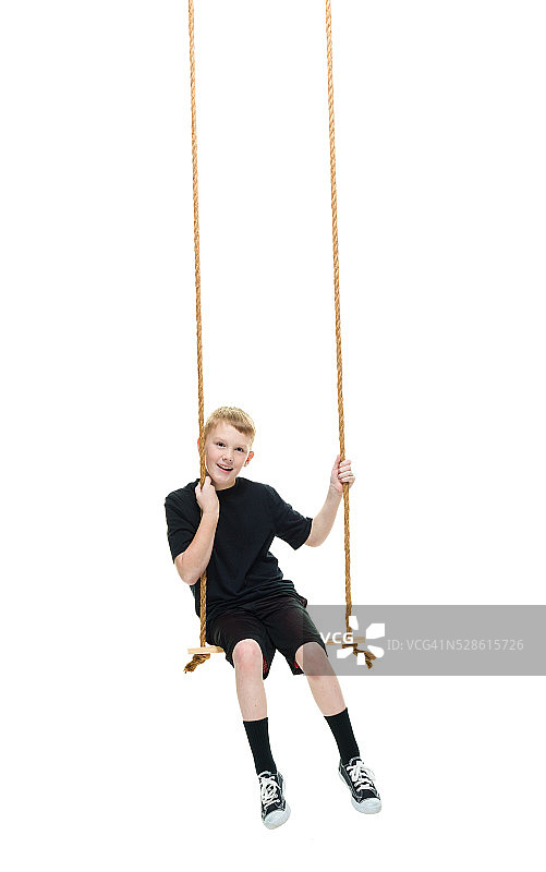 微笑的小男孩荡秋千图片素材