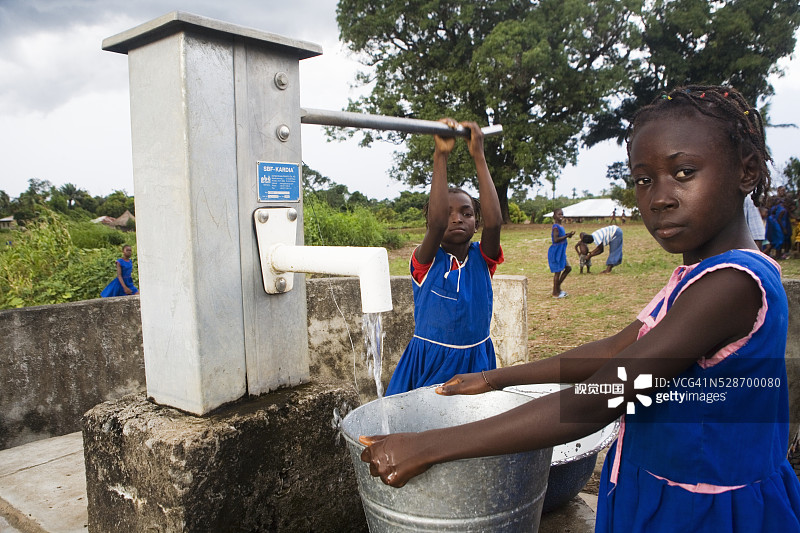 村里的女孩从井里抽水图片素材