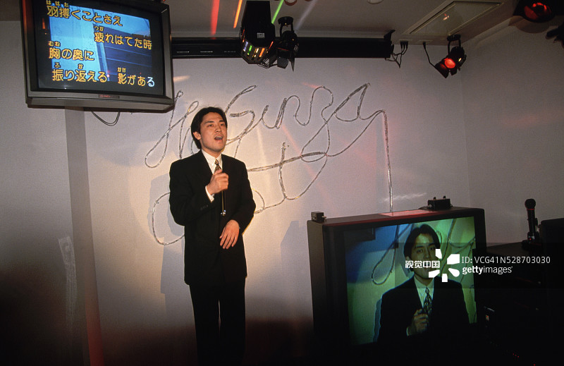 年轻男人在卡拉OK俱乐部图片素材