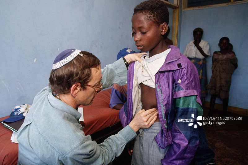 在坦桑尼亚基戈马难民营诊所检查男孩的犹太医生图片素材