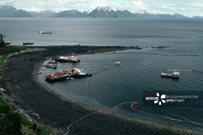 船只驶向被石油覆盖的绿岛海滩图片素材