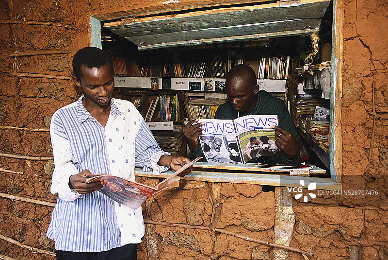 两个男人在难民营里看杂志图片素材