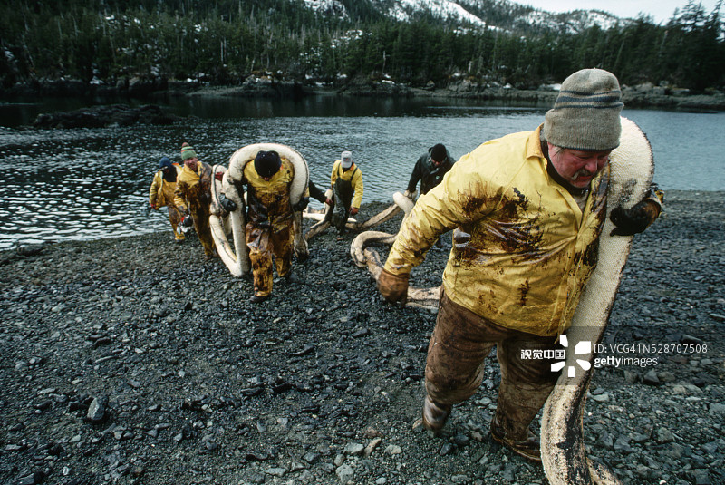 海滩上移动吊杆的渔民图片素材