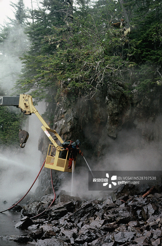 工人清理被石油覆盖的海滩图片素材