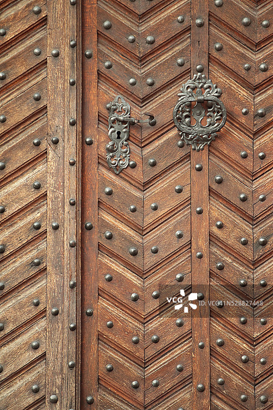 历史建筑上带铆钉和华丽门环的木门图片素材