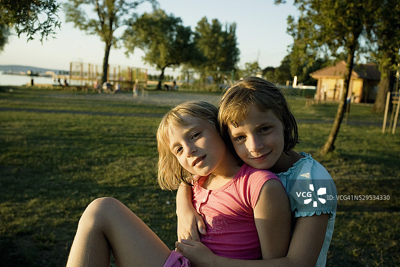 两个女孩坐在阳光下图片素材