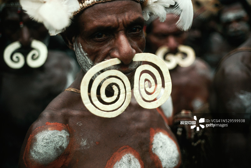 戴着弯曲的食火鸡骨头的阿斯马特男人图片素材