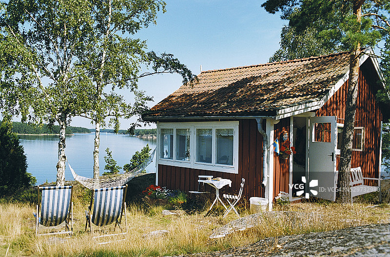 带有躺椅和吊床的小木制度假屋图片素材