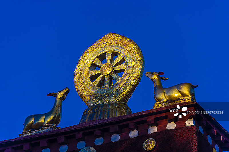 大昭寺（西藏最神圣的寺庙）顶部的金色法轮和鹿雕塑图片素材