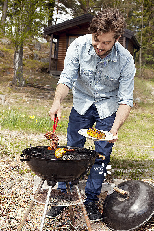 年轻男人在花园里烧烤图片素材