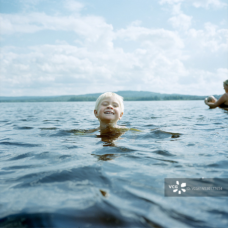 男孩在湖里游泳图片素材