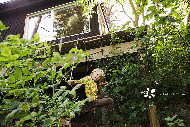 男孩在绳梯上看着镜头图片素材